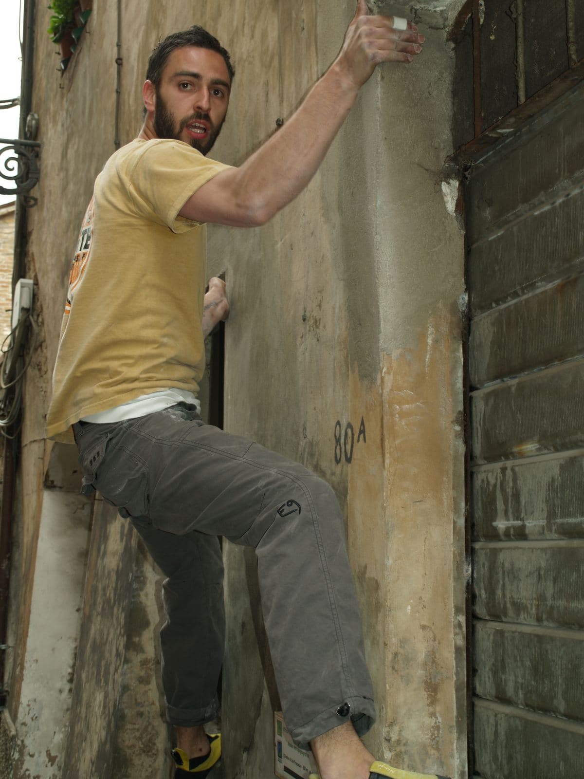 Un partecipante in partenza su un muro scrostato